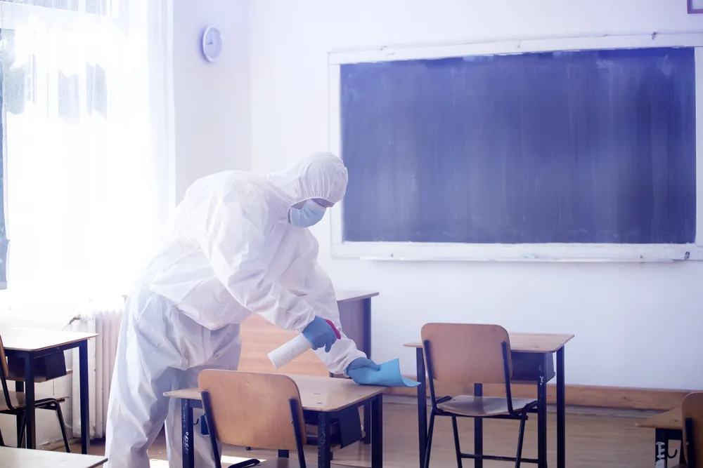 Man spraying disinfectant in a rhode island classroom